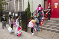 Students line up to have their temperature checked before entering PS 179 elementary school in the Kensington neighborhood, Tuesday, Sept. 29, 2020 in the Brooklyn borough of New York. Hundreds of thousands of elementary school students are heading back to classrooms Tuesday as New York City enters a high-stakes phase of resuming in-person learning during the coronavirus pandemic. (AP Photo/Mark Lennihan)