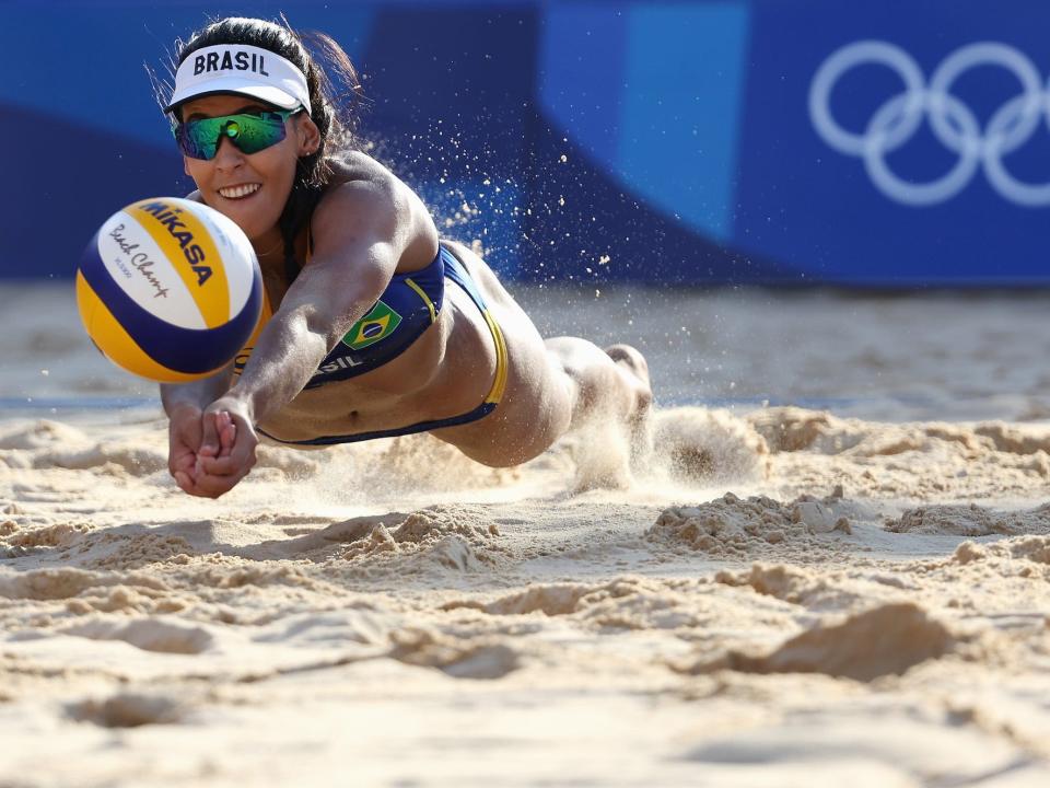 Brazilian women's beach volleyball player lays out for the ball at the Tokyo Olympics.