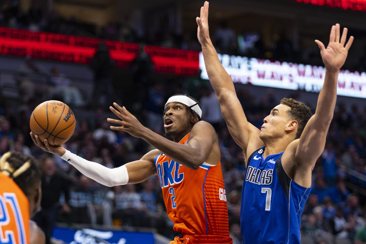 Oklahoma City Thunder guard Shai Gilgeous-Alexander (2) attempts a layup as Dallas Mavericks forward Dwight Powell (7) defends during the second half of an NBA basketball game, Saturday, Oct. 29, 2022, in Dallas. (AP Photo/Brandon Wade)