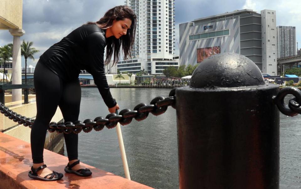 Aliza Karim, Miami Waterkeeper’s water quality research manager, dips a 100 milliliter bottle into the canal at Jose Marti Park Thursday, June 29, in Miami, Fla.