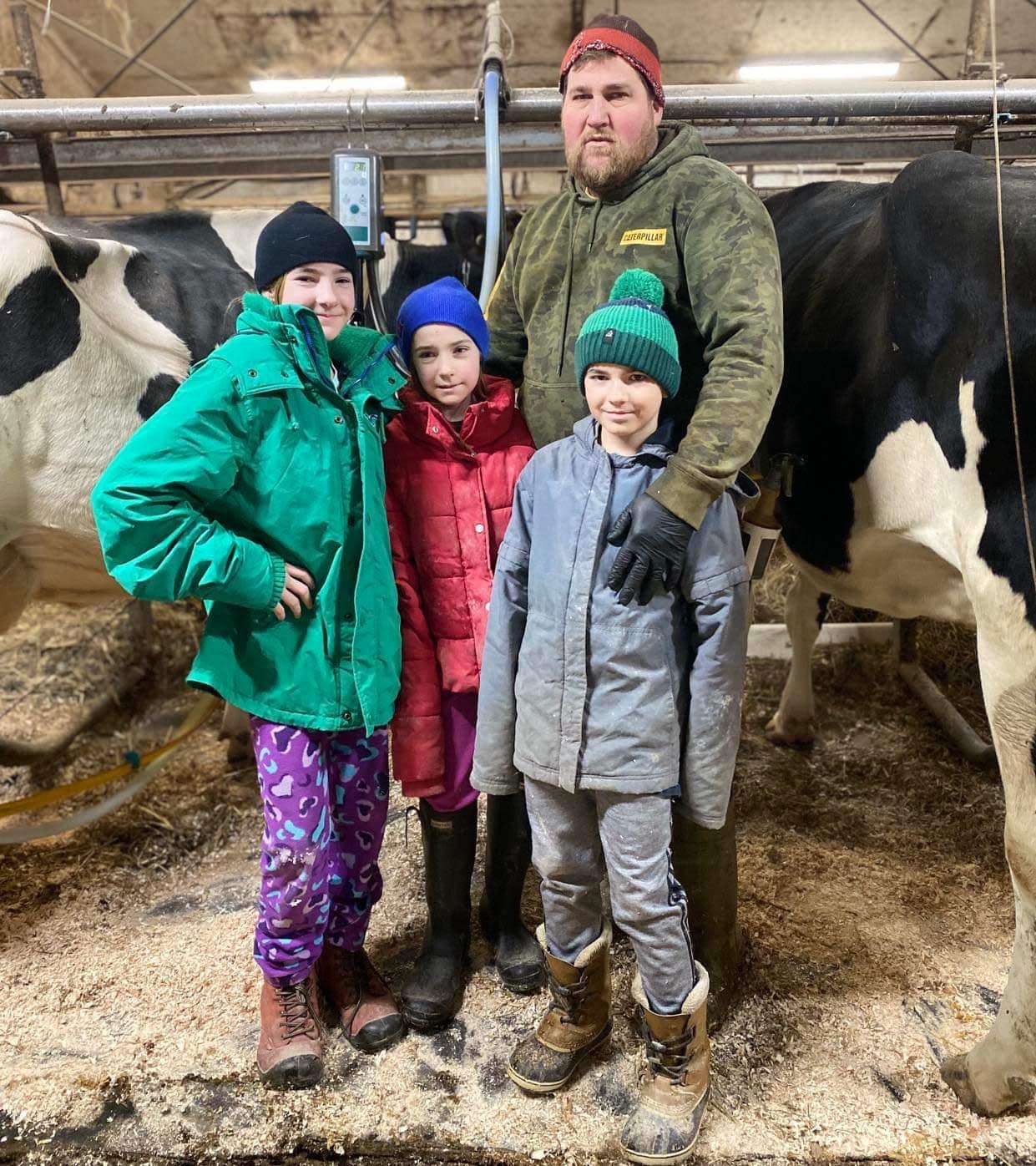 Mathieu Ferland pictured with his three children. He and his partner, Maryse Lecavalier, had to lease out their milk quota and are questioning their future in the industry due to a lack of support.  (Submitted by Maryse Lecavalier - image credit)