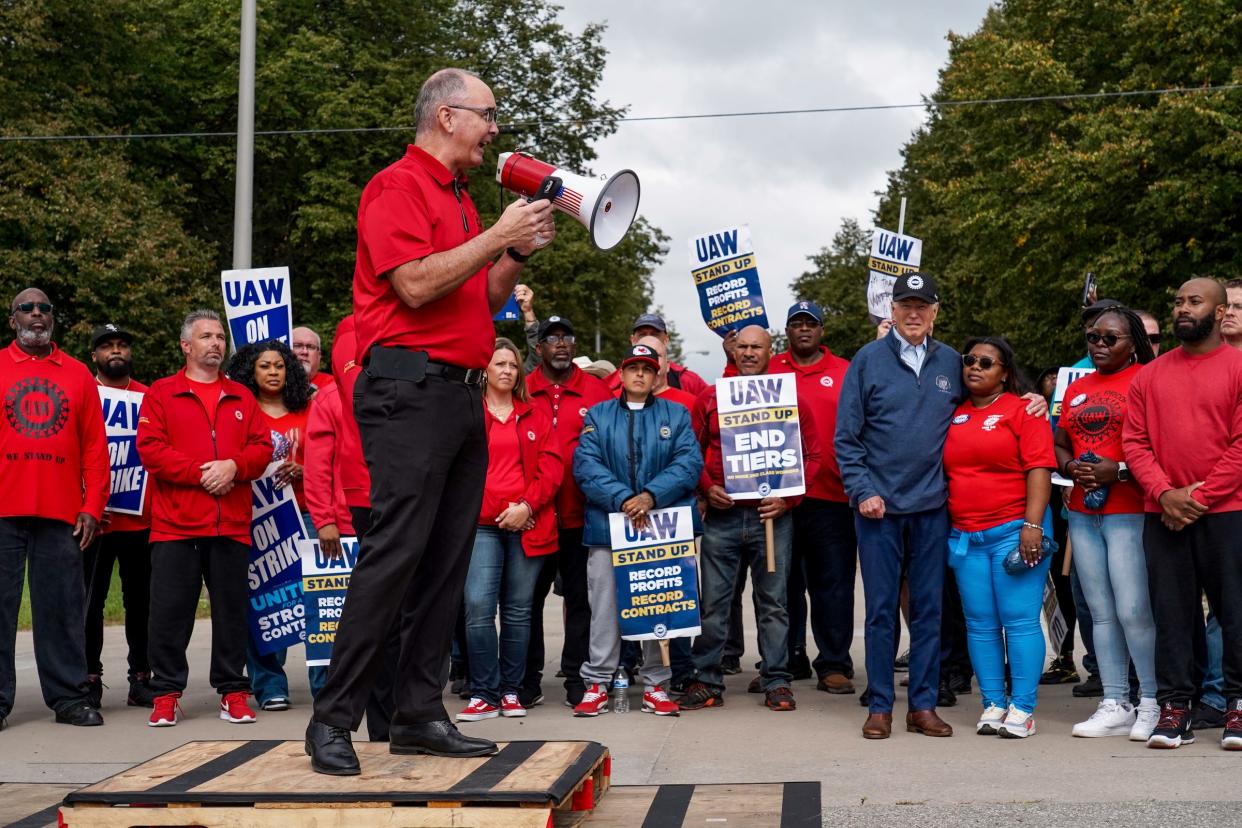 President Joe Biden stands with workers picketing as UAW President Shawn Fain speaks at General Motors Willow Run Redistribution in Belleville on Tuesday, Sept. 26, 2023, during a stop in Michigan.