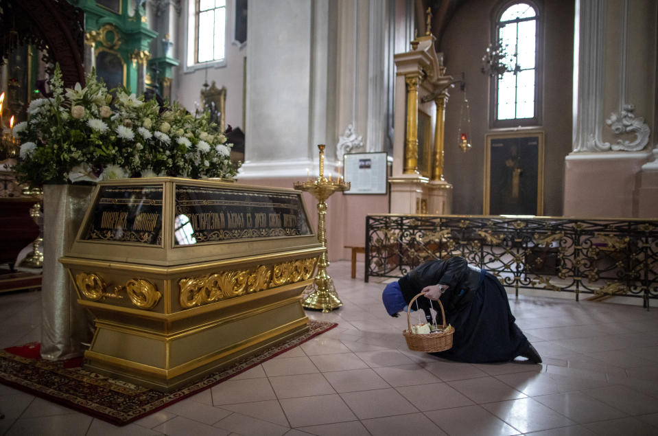 A Lithuanian Orthodox believer wearing a face mask to protect against the coronavirus, prays after a cake and Easter egg blessing ceremony at the Orthodox Church of the Holy Spirit in Vilnius, Lithuania, Saturday, April 18, 2020. For Orthodox Christians, this is normally a time of reflection, communal mourning and joyful release, of centuries-old ceremonies steeped in symbolism and tradition. But this year, Easter - by far the most significant religious holiday for the world's roughly 300 million Orthodox - has essentially been cancelled due to the COVID-19 pandemic. (AP Photo/Mindaugas Kulbis)