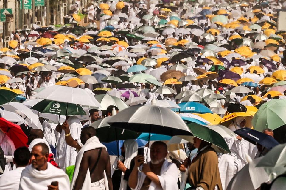 Muslim pilgrims use umbrellas to shade themselves from the sun as they arrive at the base of Mount Arafat, also known as Jabal al-Rahma or Mount of Mercy, during the annual hajj pilgrimage. Officials say more 1,3000 people have died including an American couple (AFP via Getty Images)