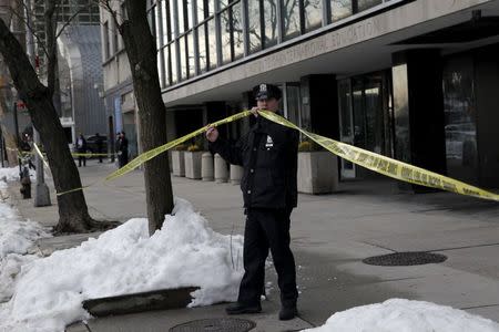 A New York City Police Department (NYPD) officer sets up police tape outside 809 First Avenue in the Manhattan borough of New York City, January 26, 2016. REUTERS/Mike Segar