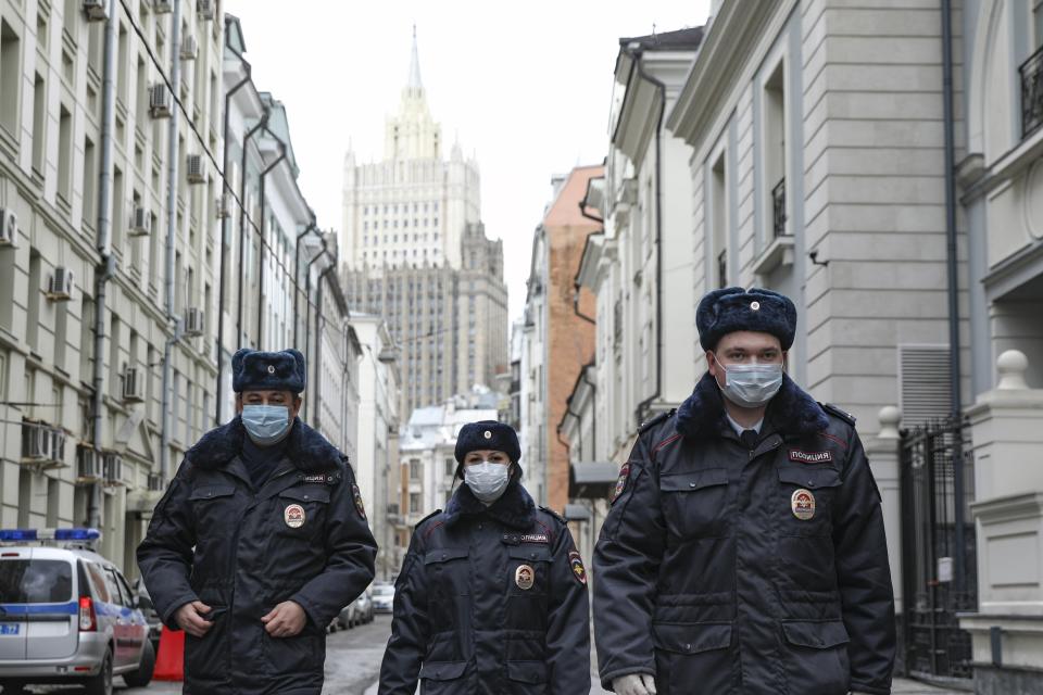 Russian police officers wearing face masks to protect against coronavirus, patrol an almost empty Arbat street in Moscow, Russia, Thursday, April 2, 2020. President Vladimir Putin has ordered most Russians to stay off work until the end of the month to curb the spread of the coronavirus. Speaking in a televised address to the nation on Thursday, Putin said he was extending the non-working policy he ordered earlier for this week to remain in force throughout April. The new coronavirus causes mild or moderate symptoms for most people, but for some, especially older adults and people with existing health problems, it can cause more severe illness or death. (Kirill Zykov, Moscow News Agency photo via AP)