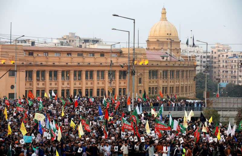 Pakistani Shi'ite Muslims carry flags and signs to protest the death of Iranian military commander Qassem Soleimani, who was killed in a airstrike near Baghdad, as they march on a road leading towards the U.S. consulate in Karachi