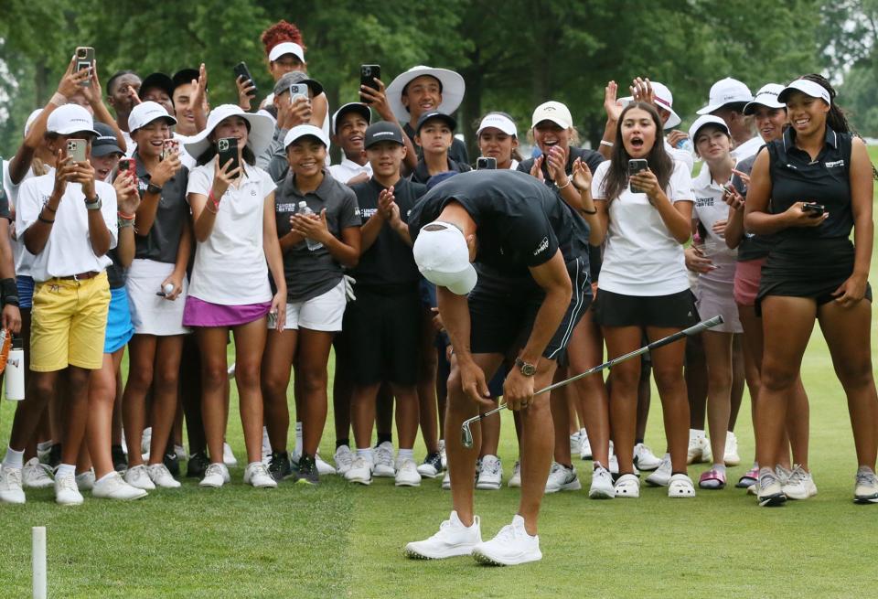 Stephen Curry reacts after his sixth attempt  to replicate Tiger Wood's famous shot in the dark on the 18th hole finally reaches the green as Underrated Golf tour players watch on the South Course at Firestone Country Club in Akron.