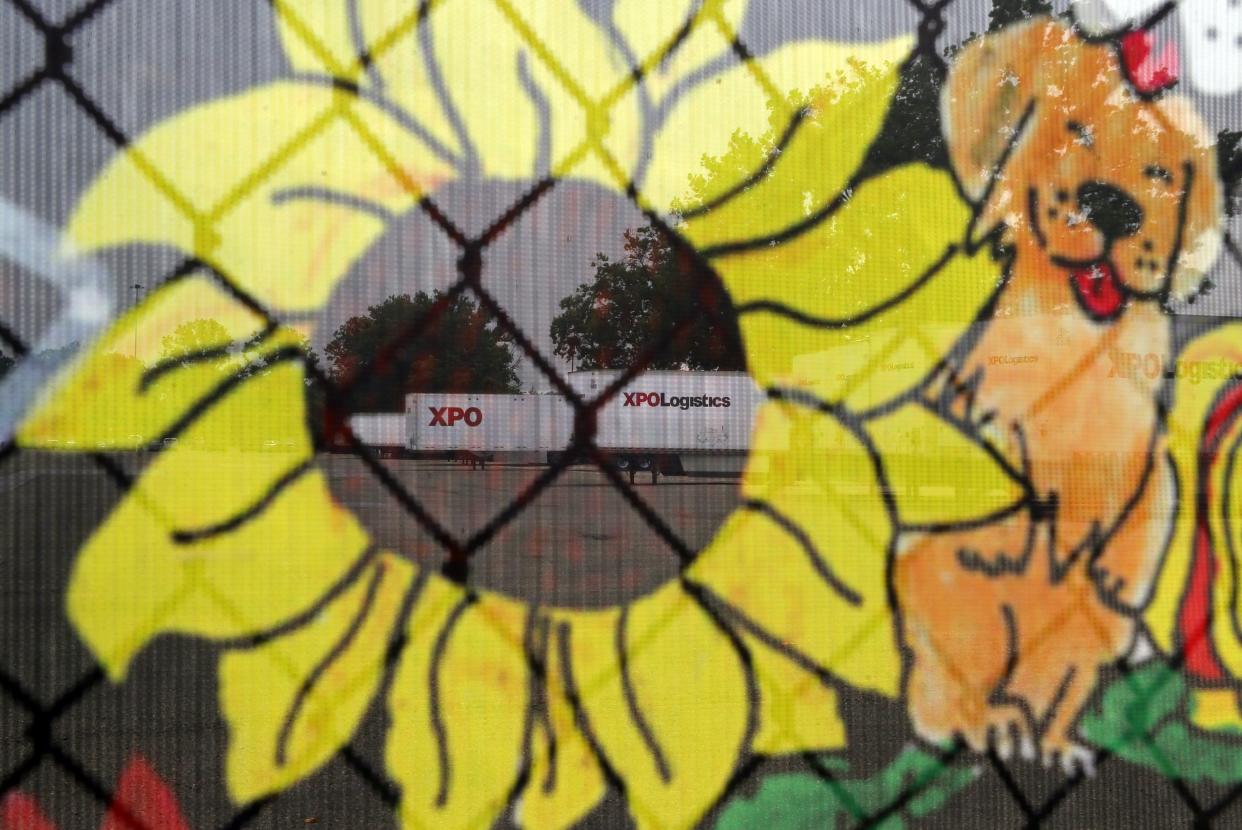 XPO Logistics trailers are pictured through the translucent banner showcasing the artwork of students from the Green Local School District.