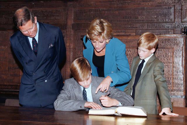 <p>PA Images via Getty</p> Prince William signs the Entrance Book surrounded by his family at Eton College in 1995