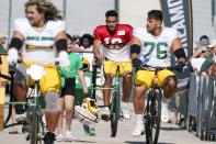 Green Bay Packers' Jordan Love rides a bike to an NFL football joint practice session with the New Orleans Saints Tuesday, Aug. 16, 2022, in Green Bay, Wis. (AP Photo/Morry Gash)