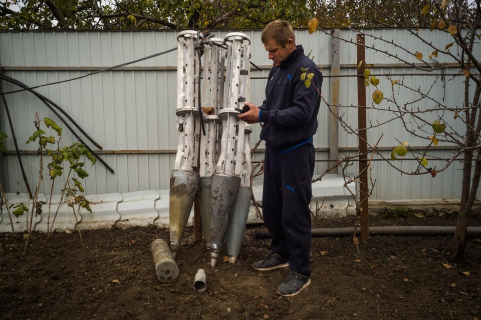 Ein Mann steht neben Streubombenträgern, die er auf seinen Feldern im Dorf Zelenyj Hai, Ukraine, gesammelt hat, 11. November 2022. - Copyright: Photo by Wojciech Grzedzinski for The Washington Post via Getty Images
