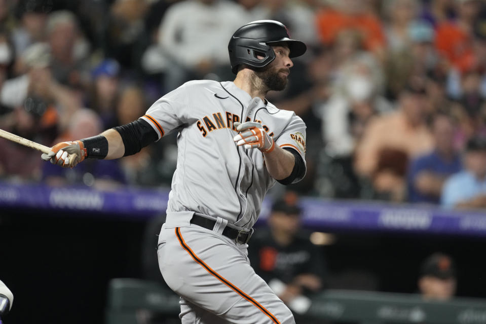 San Francisco Giants' Brandon Belt follows the flight of his single off Colorado Rockies relief pitcher Daniel Bard in the seventh inning of a baseball game Saturday, Sept. 25, 2021, in Denver. (AP Photo/David Zalubowski)