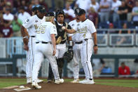 Vanderbilt head coach Tim Corbin (4) hands the ball to pitcher Chris McElvain (35) during the fifth inning against Mississippi State in Game 3 of the NCAA College World Series baseball finals, Wednesday, June 30, 2021, in Omaha, Neb. (AP Photo/John Peterson)