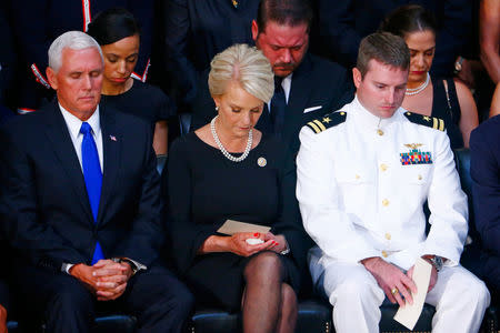 Cindy McCain, wife of late U.S. Senator John McCain, sits with son John (R) and U.S. Vice President Mike Pence as Senator John McCain's body lies in state inside the U.S. Capitol Rotunda in Washington, U.S., August 31, 2018. REUTERS/Eric Thayer