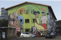 People are seen outside a block of flats in Harare, Zimbabwe, Thursday, April 2, 2020. Zimbabwe went into a lockdown for 21 days in an effort to curb the spread of the coronavirus. The new coronavirus causes mild or moderate symptoms for most people, but for some, especially older adults and people with existing health problems, it can cause more severe illness or death. (AP Photo/Tsvangirayi Mukwazhi)