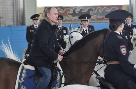 Russian President Vladimir Putin rides a horse as he attends a meeting with members of a mounted police unit, including female officers, on the eve of International Women's Day in Moscow, Russia March 7, 2019. Sputnik/Alexei Nikolsky/Kremlin via REUTERS