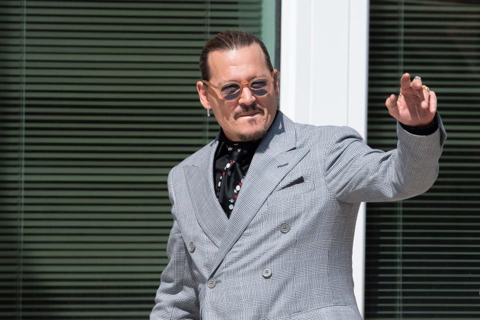 Closeup of Johnny Depp waving as he walks outside