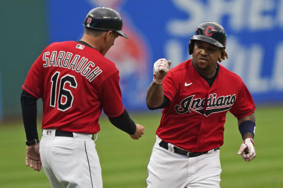 Cleveland Indians' Jose Ramirez, right, is congratulated by third base coach Mike Sarbaugh after Ramirez hit a solo home run in the first inning in the first baseball game of a doubleheader against the Detroit Tigers, Wednesday, June 30, 2021, in Cleveland. (AP Photo/Tony Dejak)