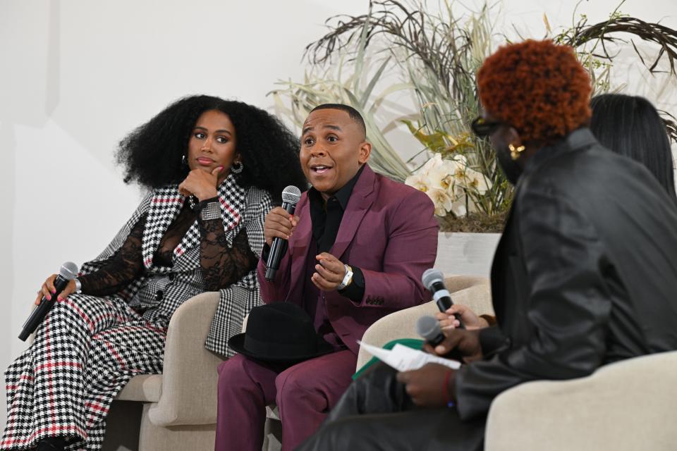 Three people sitting at a New York Fashion Week event. Rashad Robinson is the middle.