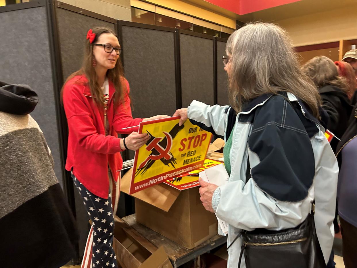 Shannon Prior, of Pataskala, hands out yard signs after the Not In Our Town Townhall on Tuesday at Licking Heights Middle School. The event was hosted by Not In Pataskala, which for months has voiced concerns about Illuminate USA, a new solar panel factory in Pataskala, over a Chinese company that jointly invested in the new company.