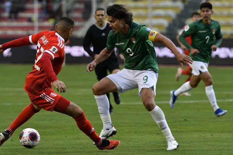 Marcelo Moreno Martins, el máximo goleador de Bolivia en eliminatorias, encara al peruano Alexander Callens; se emocionó durante la ejecución del himno, antes de su último partido como local.