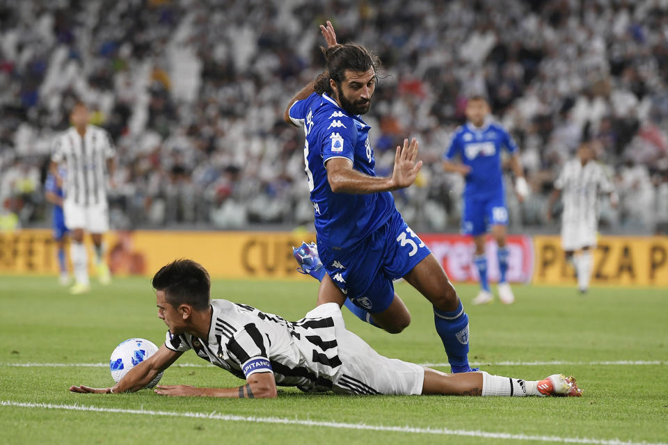 Paulo Dybala de la Juventus cae mientras pelea por el balón con Sebastiano Luperto del Empoli en el encuentro de la Serie A en Turín, Italia el sábado 28 de agosto del 2021. (Fabio Ferrari/LaPresse via AP)