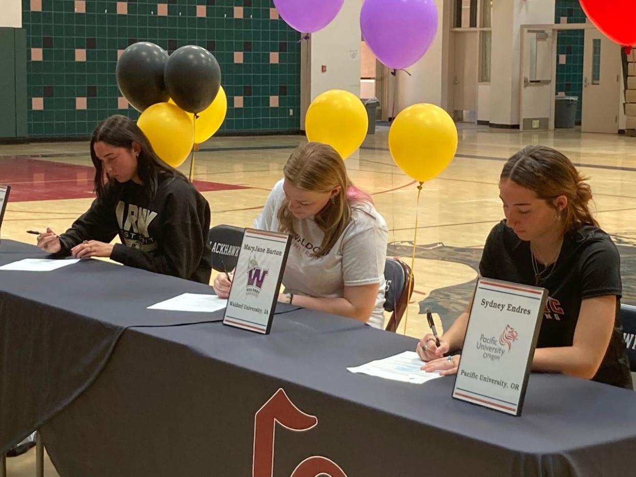 From left, Emmi Von Scherr, MaryJane Barton and Sydney Endres of La Quinta High School sign letters of intent Monday to pursue collegiate athletics