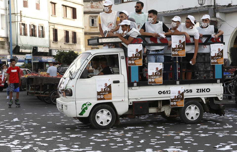 Supporters of the Constitutional Union look out from a truck during a campaign tour in Casablanca, Morocco, Monday, Sept. 6, 2021. Voting booths open on Sept. 8 for the North African kingdom's parliamentary elections, in which 395 seats in the upper house of Parliament are up for grabs. Communal and regional elections take place on the same day. (AP Photo/Abdeljalil Bounhar)