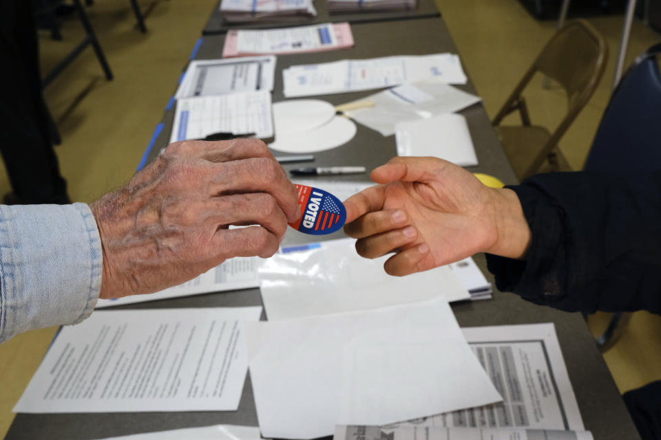 Early voter receives his I-Voted sticker, at an early voting polling station at the Ranchito Avenue Elementary School in the Panorama City section of Los Angeles on Monday, March 2, 2020. Major changes to the way people vote has election advocates on edge as Californians cast ballots in the Democratic presidential contest and other primary races. (AP Photo/Richard Vogel)