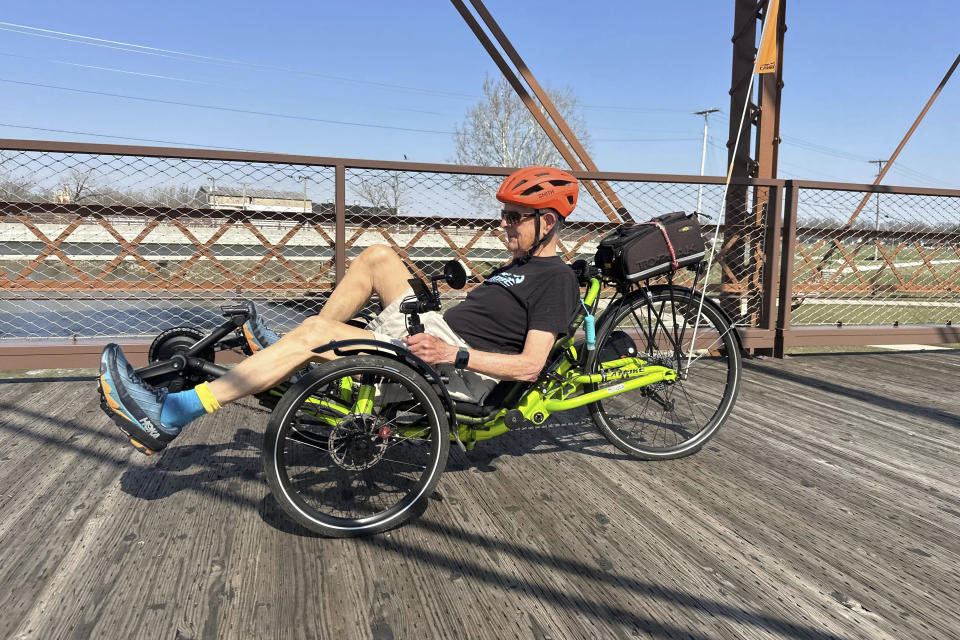 eo Robinson, 86, cycles across the Kitselman bridge connecting the Cardinal and White River Greenway trails in Muncie, Ind. on Wednesday, March 13, 2024. The Cardinal Greenways pathway born from eastern Indiana's abandoned railroad tracks will become a central cog in the Great American Rail Trail — a planned 3,700-mile network of uninterrupted trails spanning from Washington state to Washington, D.C. (AP Photo/Isabella Volmert)