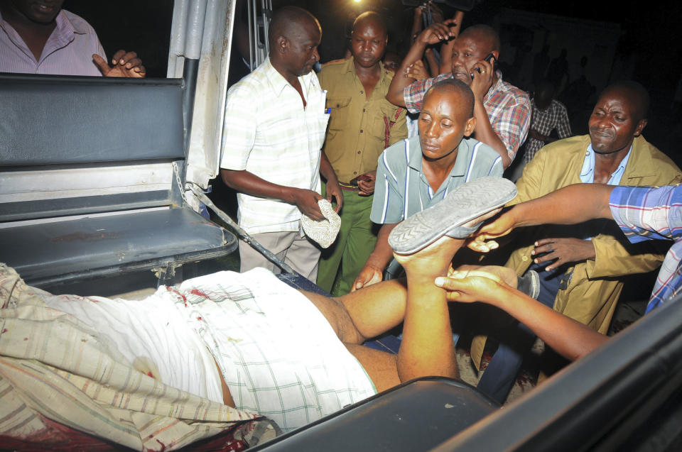 Kenyan police put the lifeless body of slain Muslim cleric Abubakar Shariff Ahmed into the back of a police pickup truck on a highway in Mombasa, Kenya, Tuesday, April 1, 2014. Attorney Mbugua Mureithi, attorney for radical Islamic leader Abubakar Shariff Ahmed, who had been sanctioned by the United States and the United Nations for supporting the al-Qaida-linked Somali militant group al-Shabab, said his client has been assassinated Tuesday along with another man whose identity has not yet been established, near the Shimo la Tewa prison in Mombasa, Kenya. (AP Photo)