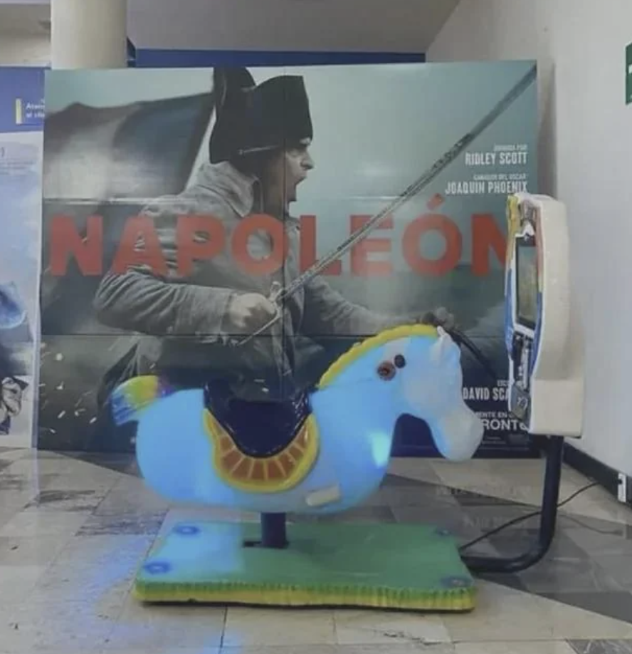 Promotional movie display for "Napoleon" with Joaquin Phoenix and a coin-operated ride-on horse in the foreground