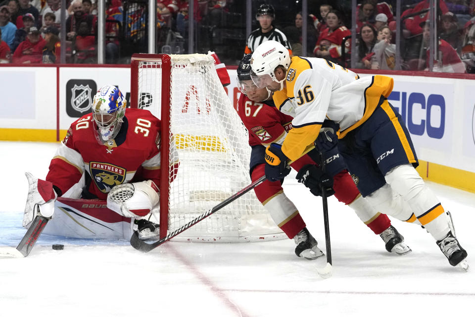 Nashville Predators' Cole Smith (36) attempts a shot on the goal as Florida Panthers goalie Spencer Knight and forward William Lockwood (67) defend during the first period of a preseason NHL hockey game, Monday, Sept. 25, 2023, in Sunrise, Fla. (AP Photo/Lynne Sladky)