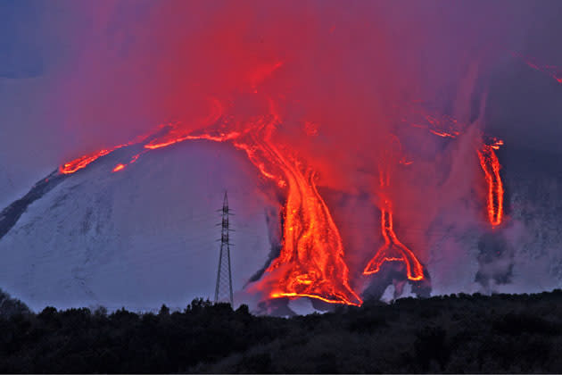 Red hot lava flows down Italian volcano Mount Etna as it erupts. The volcano erupted three times over 36 hours (Photo by Olycom SPA / Rex Features)