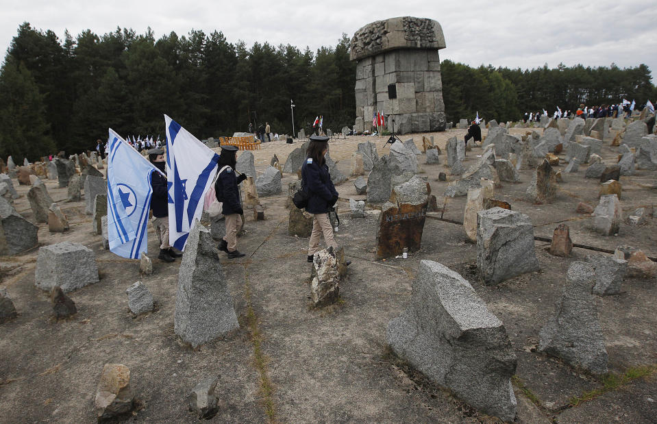 FILE _ In this file photo dated Wednesday, Oct. 2, 2013, Israeli youths with their national flags march by the monument to some 900,000 European Jews killed by the Nazis between 1941 and 1944 at the Treblinka death and labor camp, at Treblinka memorial, Poland. Two Polish historians are facing a libel trial for a scholarly examination of Polish behavior during World War II, a case whose outcome is expected to determine the fate of independent Holocaust research under Poland’s nationalist government. A verdict is expected Feb. 9. (AP Photo/Czarek Sokolowski, File)