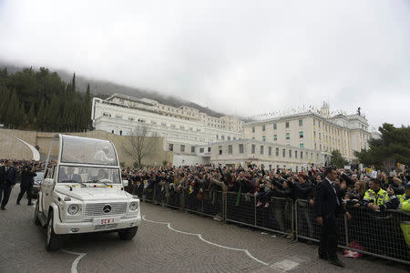 Pope Francis waves as he leaves the Casa Sollievo della Sofferenza hospital in San Giovanni Rotondo, Italy March 17, 2018. Osservatore Romano/Handout via REUTERS