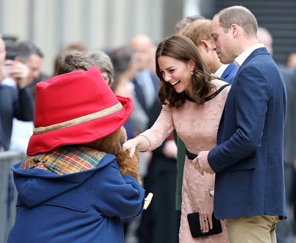 Prince William, Duke of Cambridge looks on as Paddington Bear kisses Catherine, Duchess of Cambridge's hand whilst they attend the Charities Forum Event at Paddington Station on October 16, 2017.