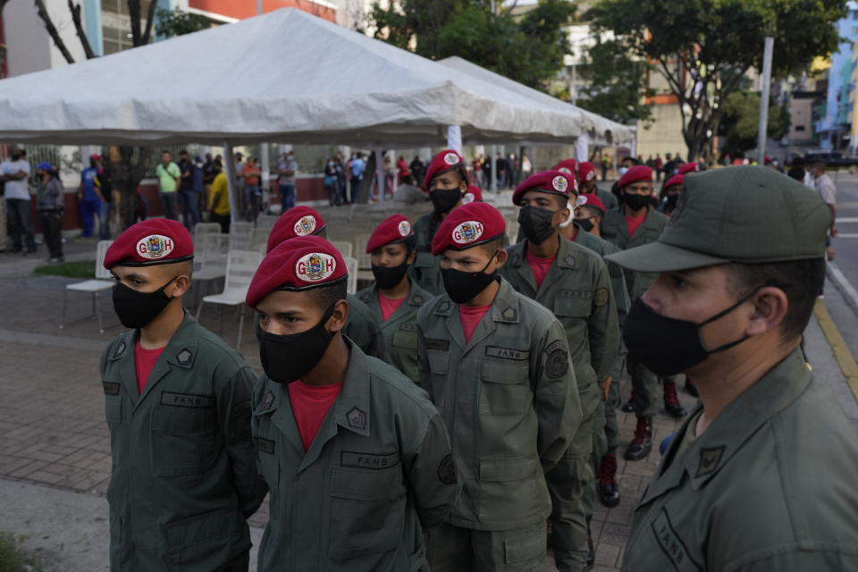 Members of the armed forces line up to vote during regional elections, at a polling station in Caracas, Venezuela, Sunday, Nov. 21, 2021. Venezuelans go to the polls to elect state governors and other local officials. (AP Photo/Ariana Cubillos)