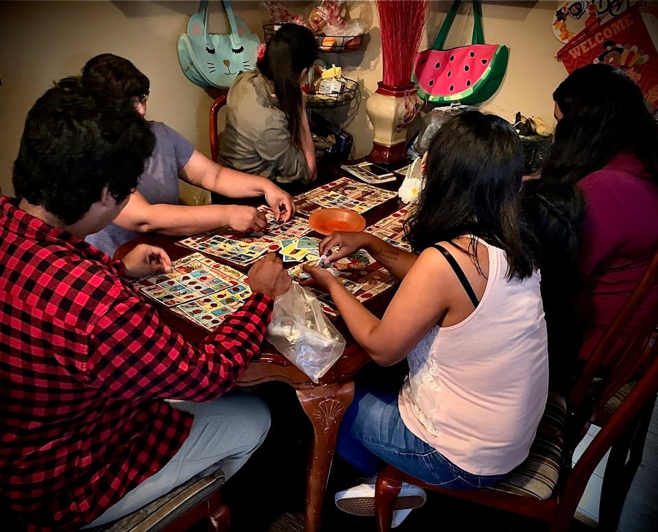 A Ventura County woman, who is slated to be deported June 11, plays lotería with her four children at their home. The Desert Sun is only using the woman's last name, Lopez, to protect her family’s privacy.
