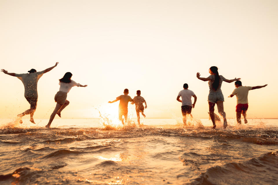 people running into the ocean