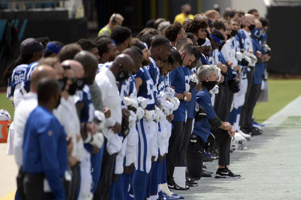 Indianapolis Colts head coach Frank Reich, center, kneels the national anthem during the first half of an NFL football game, Sunday, Sept. 13, 2020, in Jacksonville, Fla. (AP Photo/Phelan M. Ebenhack)