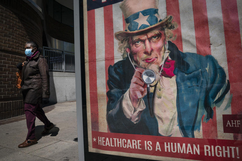 A woman wears a mask as she walks past a bus stop on 14th Street in downtown Washington, D.C., on April 15, 2020. | Drew Angerer—Getty Images