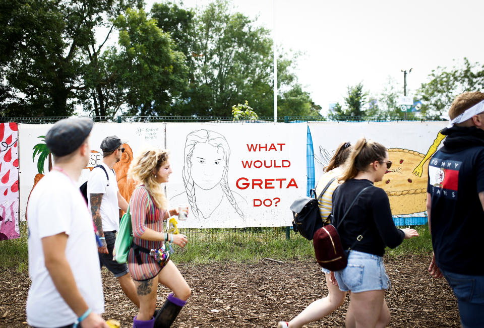 Revellers walk past a Greta Thunberg mural at Glastonbury Festival at Worthy farm in Somerset, Britain June 26, 2019. REUTERS/Henry Nicholls