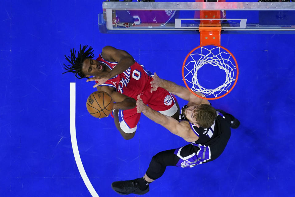 Philadelphia 76ers' Tyrese Maxey, left, goes up for a shot against Sacramento Kings' Domantas Sabonis during the first half of an NBA basketball game, Friday, Jan. 12, 2024, in Philadelphia. (AP Photo/Matt Slocum)