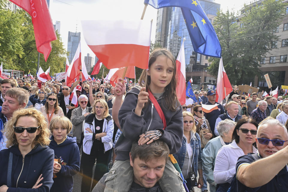 Demonstrators wave Polish flags during a march to support the opposition against the governing populist Law and Justice party in Warsaw, Poland, Sunday, Oct. 1, 2023. Polish opposition leader Donald Tusk seeks to boost his election chances for the parliament elections on Oct. 15, 2023, leading the rally in the Polish capital. (AP Photo/Rafal Oleksiewicz)