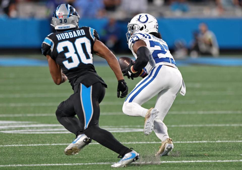 Indianapolis Colts cornerback Kenny Moore II, right, intercepts a Bryce Young pass meant for Carolina Panthers running back Chuba Hubbard (left). Moore took the interception back for a touchdown, one of his two scores on the day in a 27-13 win for the Colts.