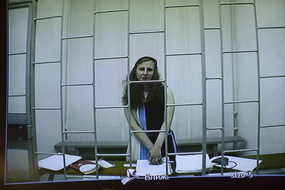 Jailed feminist punk band Pussy Riot member Maria Alekhina appears on a TV screen during a live session with the court during a hearing of her appeal in a courtroom in Perm, 1200 kms (750 miles) east of Moscow, Russia, Wednesday, July 24, 2013. (AP Photo/Alexander Agafonov)