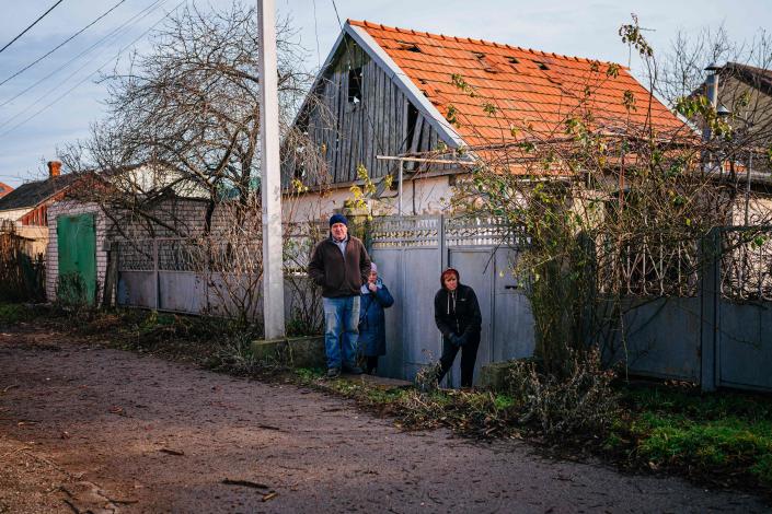 Residents take cover next to a fence after hearing the sound of a military jet in the city of Kherson on 1 January (AFP/Getty)