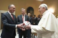 Bayern Munich CEO Karl-Heinz Rummenigge (L) gives a soccer ball to Pope Francis before his weekly audience in Saint Peter's Square at the Vatican October 22, 2014. REUTERS/Osservatore Romano